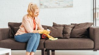 Frau reinigt die Polster ihrer Couch
